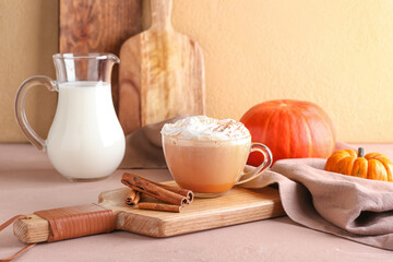 Cup of pumpkin cappuccino on table