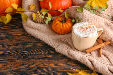 Composition with cup of pumpkin cappuccino on wooden background