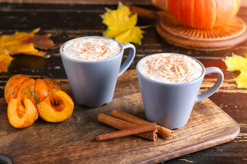 Cups of pumpkin cappuccino on table