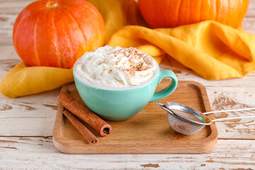 Cup of pumpkin cappuccino on table