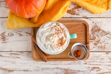 Cup of pumpkin cappuccino on table