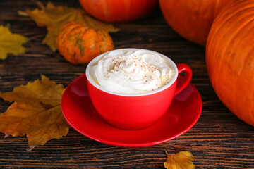 Cup of pumpkin cappuccino on table