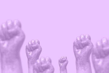 woman fists covered in purple glitter on violet background toned
