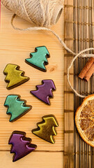 Handmade chocolate Christmas trees in trendy colors in 2021. Layout on a wooden table.