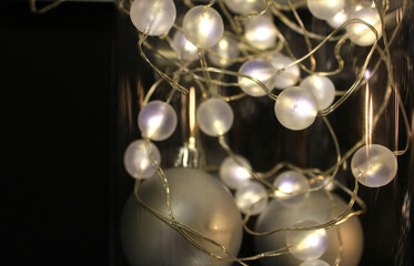 shining garland on a black background. Christmas time. Copy space for text, banner. The concept of the approaching Christmas and New Year, holiday sales. New Year, Christmas background in black colors