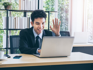 Young handsome Asian businessman in suit in office.
