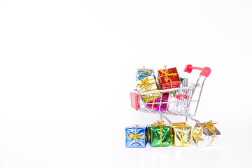 Colorful gift box in shopping cart with space on white background, Christmas and New year concept, online birthday gift shopping