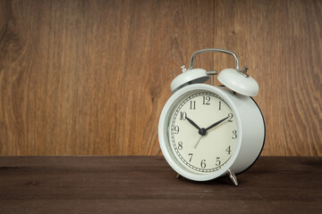 Retro alarm clock on wooden background. Old fashioned alarm clock