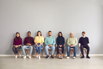 Multiethnic people sitting in corridor waiting for their turn to see doctor or to have job interview