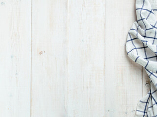 View from above on white wooden table with linen kitchen towel or textile napkin. Blue tablecloth on white wood tabletop. Copy space for text. Can use as mock up for design.