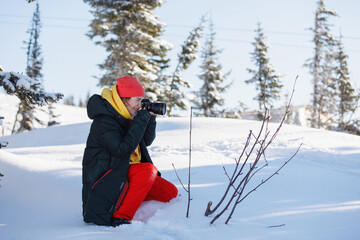 Fototapeta na wymiar Photographer in the open air in winter ski clothes.
