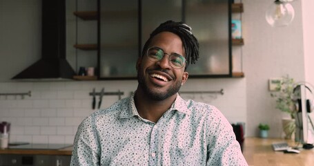 Head shot african guy sit at home office kitchen conduct negotiations talk distantly use video call app, webcam view, show thumbs up express positive feedback, advertise services, enjoy carefree chat