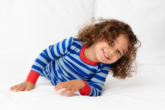 Happy Toddler Boy Lying On White Bed