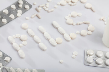 Fototapeta na wymiar Word PILLS made of tablets on white background. Concept of medicine and pharmaceutics