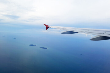A Beautiful small island in Java Sea viewed from the airplane window with airplane's wing.