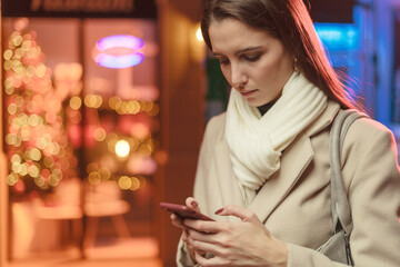 Woman walking in the city streets and using her phone
