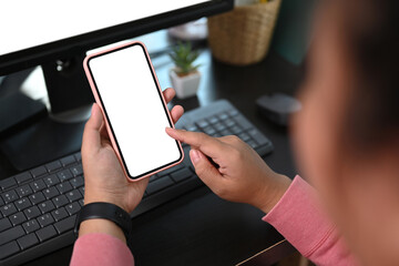 Cropped shot of young woman using mobile phone with blank screen for graphics display montage.