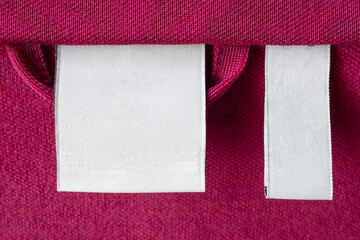 Blank white laundry care clothes label on red fabric texture background