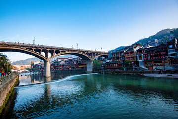 the river, the boat, stone bridge and the old houses at ancient phoenix town in the morning at Hunan, China.