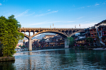 the river, the boat, stone bridge and the old houses at ancient phoenix town in the morning at Hunan, China.