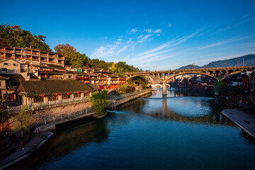 the river, the boat, stone bridge and the old houses at ancient phoenix town in the morning at Hunan, China.