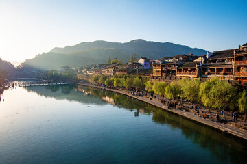 Fototapeta na wymiar the river, the boat, stone bridge and the old houses at ancient phoenix town in the morning at Hunan, China.