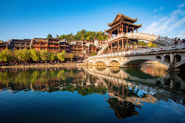 the river, the boat, stone bridge and the old houses at ancient phoenix town in the morning at Hunan, China.