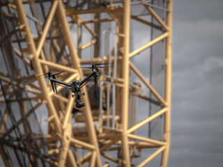 drone flies for inspection in front of a huge crane