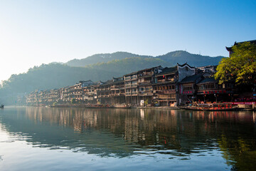 Fototapeta premium the river, the boat, stone bridge and the old houses at ancient phoenix town in the morning at Hunan, China.