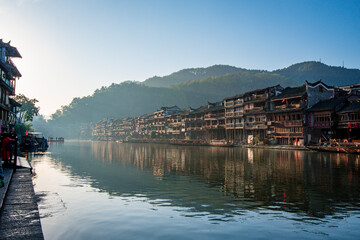 the river, the boat, stone bridge and the old houses at ancient phoenix town in the morning at Hunan, China.
