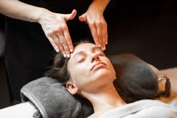 Obraz na płótnie Canvas Young woman receiving a facial massage, relaxing at Spa salon