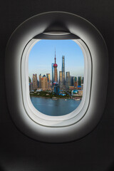 Fototapeta na wymiar Shanghai, China - May 23, 2018: Sunset view of the modern Pudong skyline in in airplane window