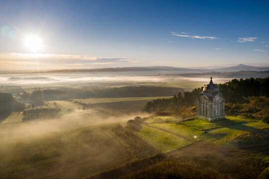 Mausoleum sitting on top of a hill with misty low cloud in the morning and dramatic landscape. - Powered by Adobe