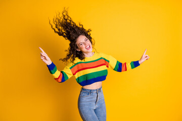 Photo of funky girl dance fly hair direct fingers wear striped cropped sweater jeans isolated yellow color background