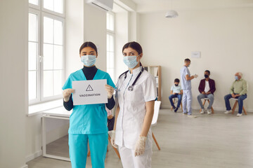 Young doctors in medical face masks promoting vaccination campaign that saves lives