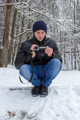 Fototapeta na wymiar shooting in the winter on a video camera,in winter a man sits and shoots nature on an amateur camera