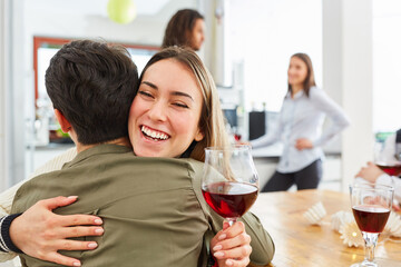 Two friends hug each other at a party in the kitchen