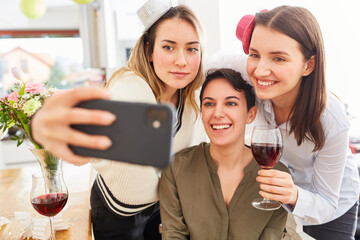 Happy girlfriends make selfie with bride at hen party