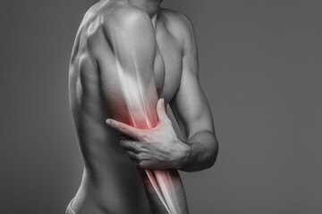 Naklejka premium Arm pain, the person is holding the painful elbow