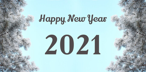 Happy New Year 2021 words. Winter landscape with blue sky. Snow covered frozen pine tree
