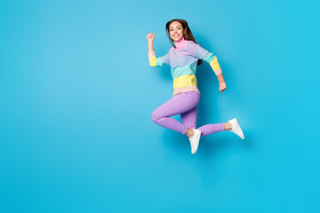 Full length body size view of attractive active purposeful cheerful girl jumping running isolated on bright blue color background