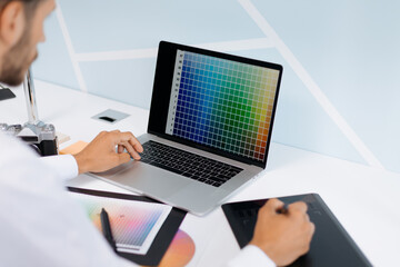 designer works on a computer and a graphic tablet at the same time.