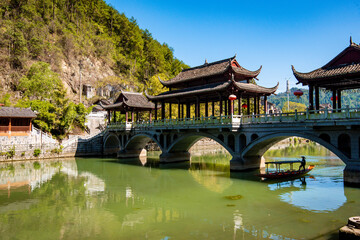 the river, the boat, stone bridge and the old houses at ancient phoenix town in the morning at...