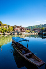 Obraz premium the river, the boat, stone bridge and the old houses at ancient phoenix town in the morning at Hunan, China.