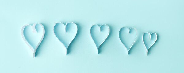 Row of Paper hearts over the blue pastel background. Abstract background with paper cut shapes. Sainte Valentine, mother's day, birthday wedding greeting cards, invitation, celebration concept, banner