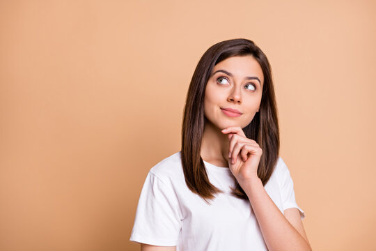 Photo portrait of dreamy girl thoughtful looking copyspace touching chin isolated pastel beige color background
