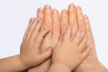 Small children's hands in the hands of an old grandmother. Old age and childhood, communication of grandmother with grandson, aging, life