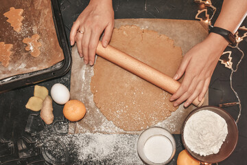 cut gingerbread out of the dough using a gingerbread mold, top view, raw dough with cinnamon...