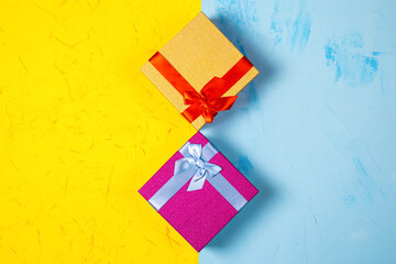 Colored square gift boxes on concrete background, flat lay, top view