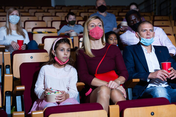 caucasian family sitting at premiere in cinema during pandemic